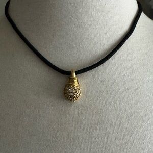 Gold tone rhinestone pendant on black cord necklace
